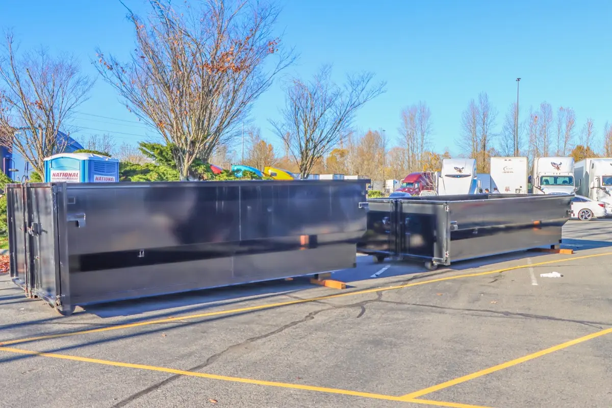 Professional dumpster rental service with roll-off container on residential driveway in Taos